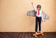 Kind als Flugzeug verkleidet auf Skatebord