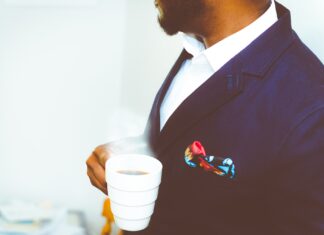 Mann mit Kaffeetasse im Anzug