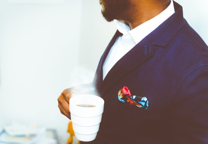 Mann mit Kaffeetasse im Anzug