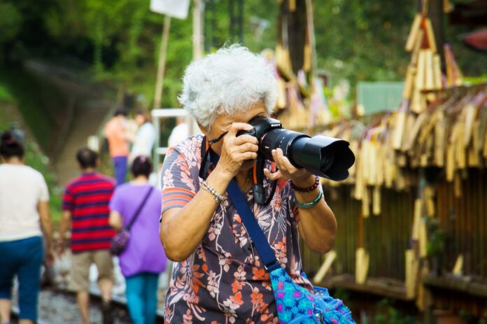 alte Frau mit moderner Kamera