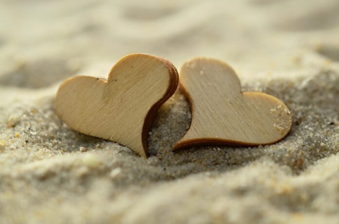2 Herzen aus Holz im Sand