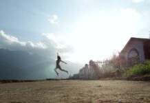 Frau springt vor Glück am Strand