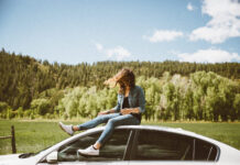 junge Frau sitzt auf einem Auto