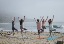 Frauen machen Yoga am Strand