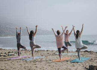 Frauen machen Yoga am Strand