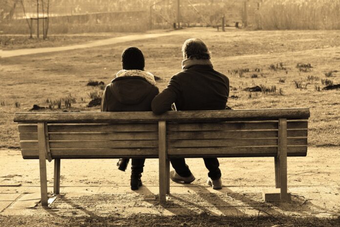 2 Menschen sitzen auf der Bank und reden