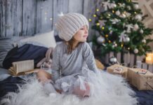 kleines Mädchen zu Weihnachten vor dem Baum
