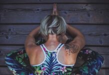 junge Frau macht eine schwere Yogapose in einem super Outfit
