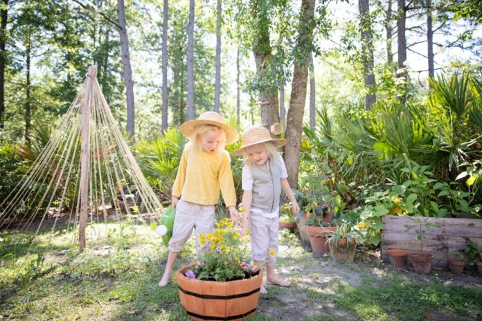 zwei glückliche kleine Mädchen bei der Gartenarbeit